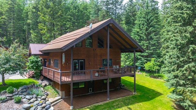 125 Wagon Wheel Rd, Whitefish, MT 59937 - rear view of property featuring a yard, a wooden deck, a forest view, and a metal roof