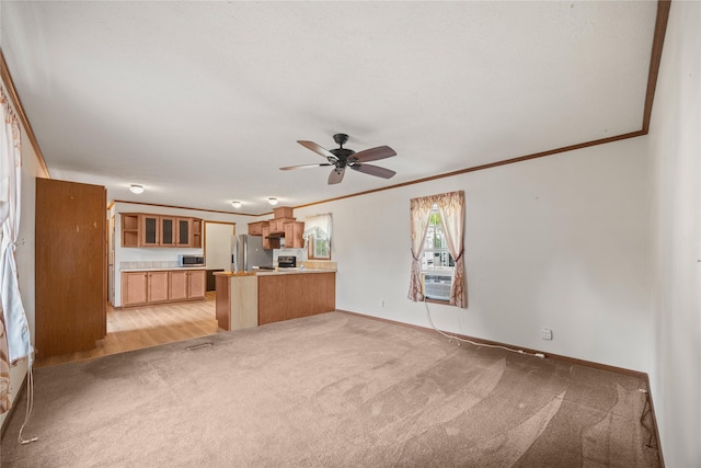1100 E Oregon St Unit 13, Kalispell, MT 59901 - unfurnished living room with light carpet, crown molding, and ceiling fan