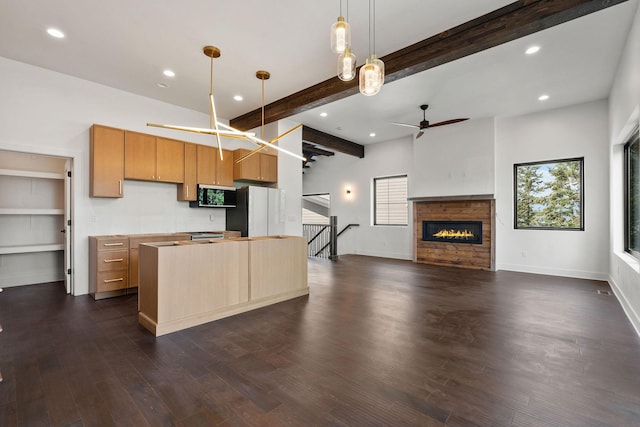 211 Whisper Ridge Dr, Bigfork, MT 59911 - kitchen with freestanding refrigerator, a ceiling fan, a glass covered fireplace, recessed lighting, and beamed ceiling