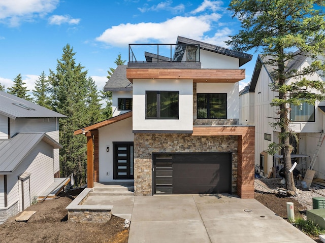 211 Whisper Ridge Dr, Bigfork, MT 59911 - modern home featuring stucco siding, concrete driveway, stone siding, a balcony, and a garage