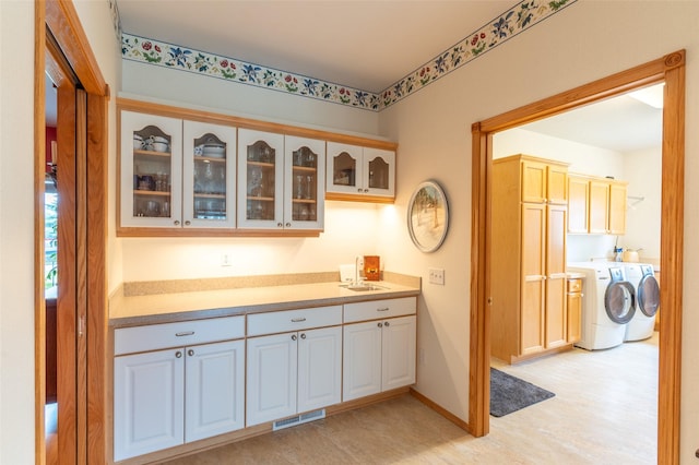 286 Arbour Dr W, Kalispell, MT 59901 - kitchen with washer and clothes dryer, glass insert cabinets, and light countertops
