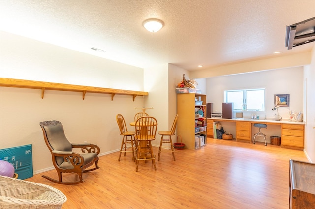286 Arbour Dr W, Kalispell, MT 59901 - sitting room featuring wood finished floors, a textured ceiling, built in desk, and recessed lighting