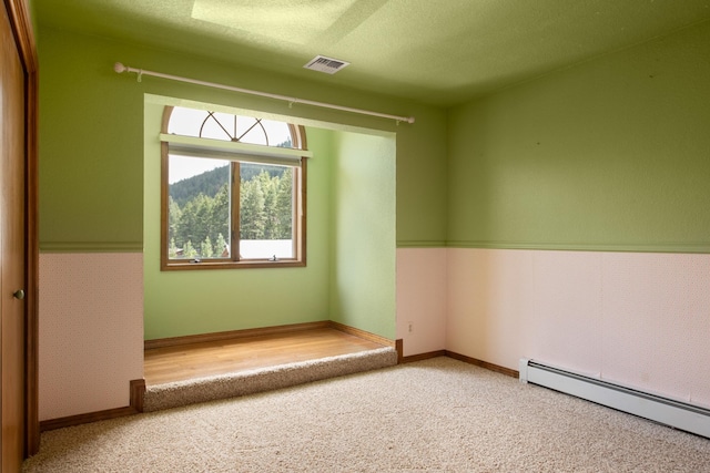 9995 Obrien Creek Rd, Missoula, MT 59804 - carpeted empty room with a baseboard heating unit, plenty of natural light, and a wainscoted wall
