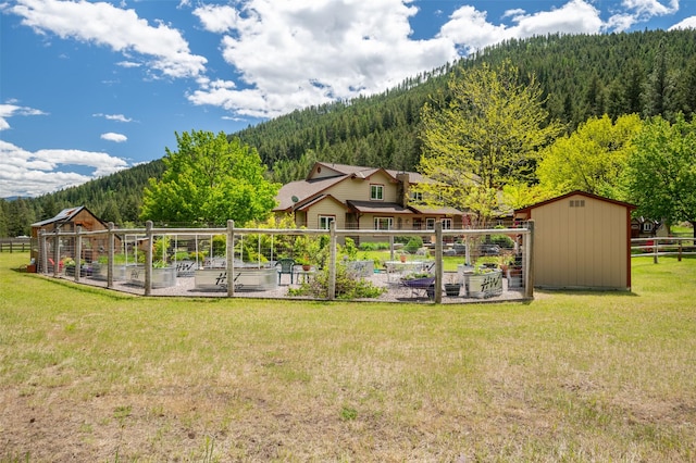 9995 Obrien Creek Rd, Missoula, MT 59804 - view of yard with a garden, a view of trees, a shed, and a mountain view