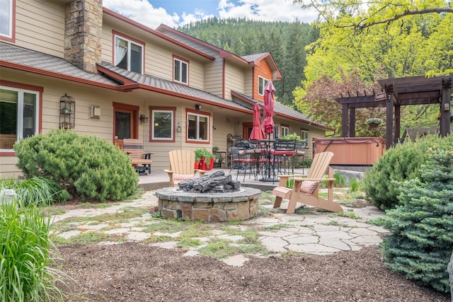 9995 Obrien Creek Rd, Missoula, MT 59804 - view of yard with a hot tub, a fire pit, a patio, a forest view, and outdoor dining area