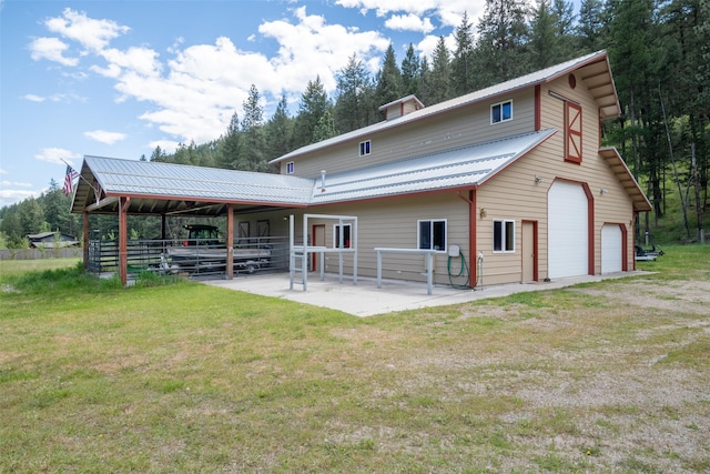 9995 Obrien Creek Rd, Missoula, MT 59804 - rear view of house featuring a detached garage, a metal roof, a yard, and a patio area