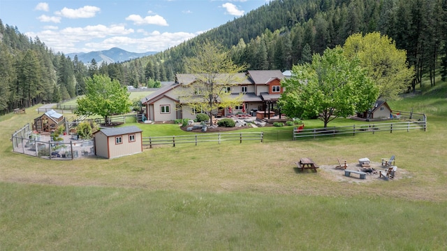 9995 Obrien Creek Rd, Missoula, MT 59804 - fenced backyard with an outdoor fire pit, a shed, a mountain view, and a view of trees