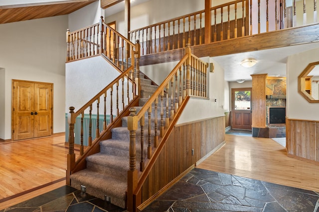9995 Obrien Creek Rd, Missoula, MT 59804 - stairway with wainscoting, wooden walls, wood finished floors, and high vaulted ceiling