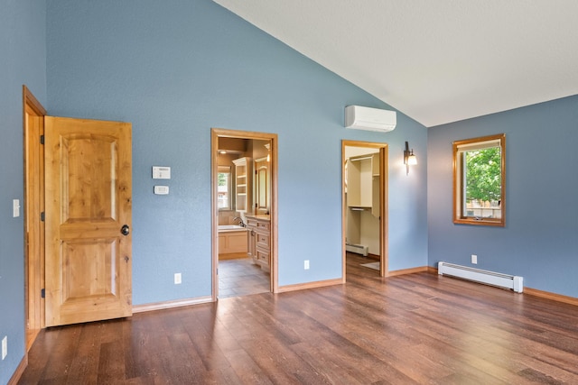 9995 Obrien Creek Rd, Missoula, MT 59804 - unfurnished bedroom featuring a baseboard heating unit, a wall unit AC, wood finished floors, a spacious closet, and high vaulted ceiling