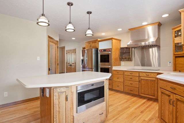 9995 Obrien Creek Rd, Missoula, MT 59804 - kitchen featuring stainless steel appliances, wall chimney exhaust hood, light wood finished floors, light countertops, and decorative light fixtures