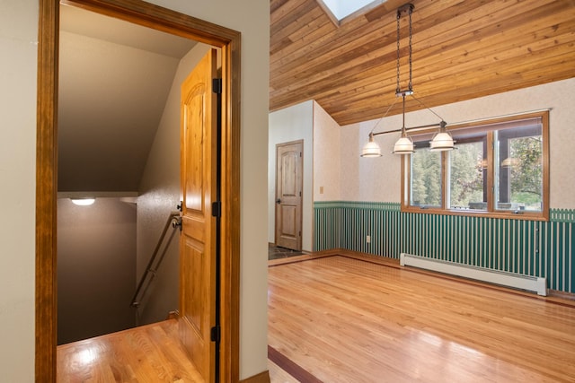 9995 Obrien Creek Rd, Missoula, MT 59804 - hall with a baseboard radiator, an upstairs landing, vaulted ceiling, wainscoting, and wood finished floors