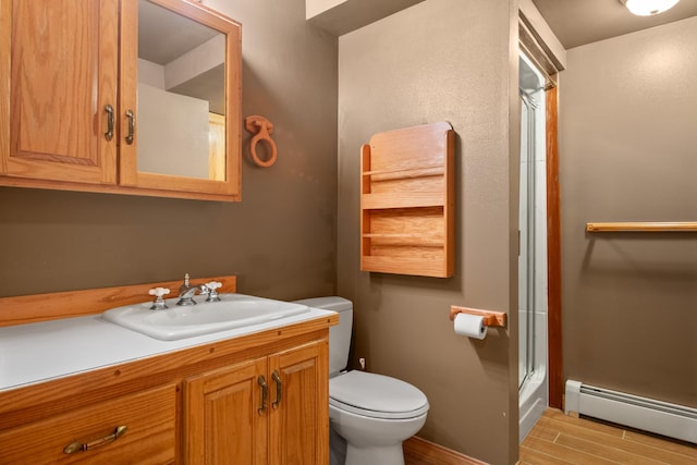 9995 Obrien Creek Rd, Missoula, MT 59804 - full bath with a baseboard radiator, wood finished floors, a shower with shower door, and vanity