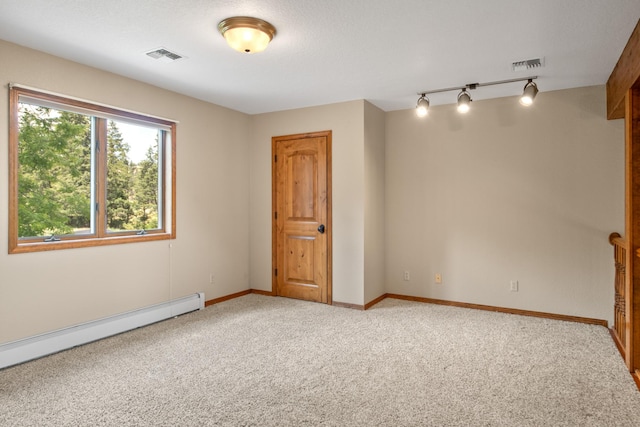 9995 Obrien Creek Rd, Missoula, MT 59804 - unfurnished room featuring rail lighting, a baseboard radiator, and light colored carpet