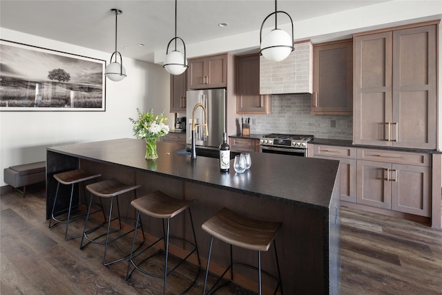 311E Akers Ln Unit E, Whitefish, MT 59937 - kitchen with stainless steel appliances, dark countertops, dark wood-style floors, decorative backsplash, and recessed lighting