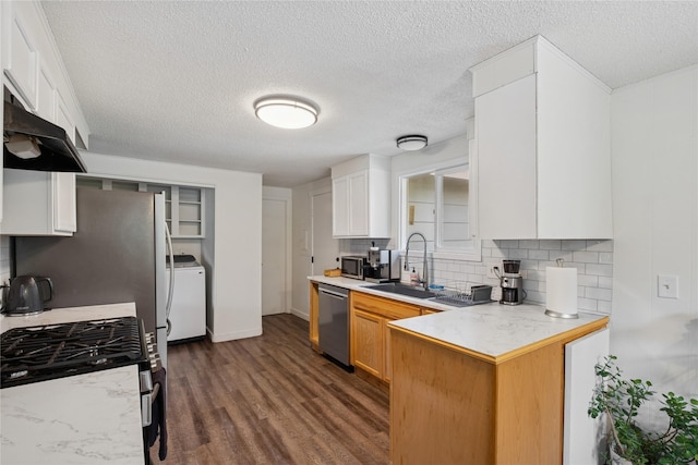1970 Benchmark Ln, Whitefish, MT 59937 - kitchen featuring stainless steel appliances, washer / clothes dryer, under cabinet range hood, tasteful backsplash, and a textured ceiling