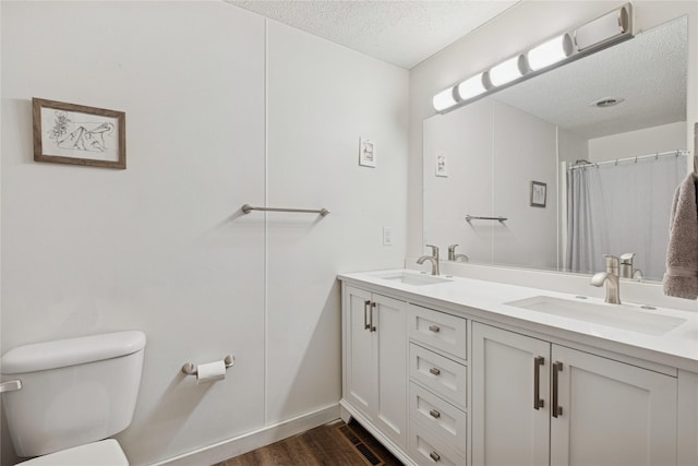 1970 Benchmark Ln, Whitefish, MT 59937 - bathroom featuring double vanity, a textured ceiling, and wood finished floors