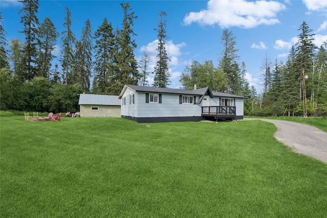 1970 Benchmark Ln, Whitefish, MT 59937 - manufactured / mobile home featuring a wooden deck, a front lawn, and dirt driveway