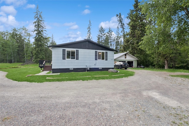 1970 Benchmark Ln, Whitefish, MT 59937 - view of side of property with crawl space, a lawn, a deck, driveway, and a garage