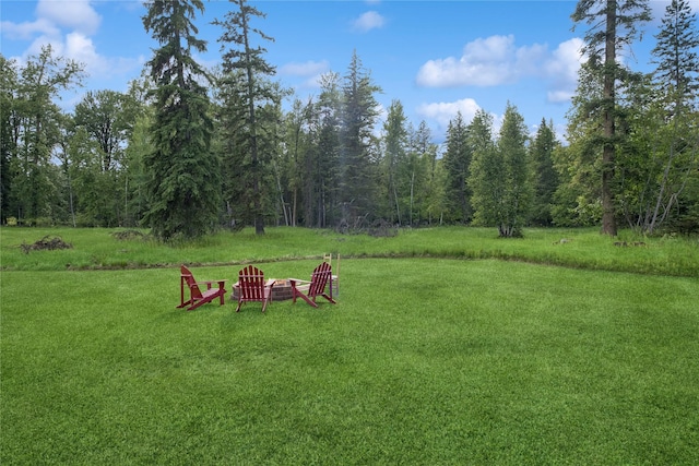 1970 Benchmark Ln, Whitefish, MT 59937 - view of grassy yard featuring a wooded view and a fire pit