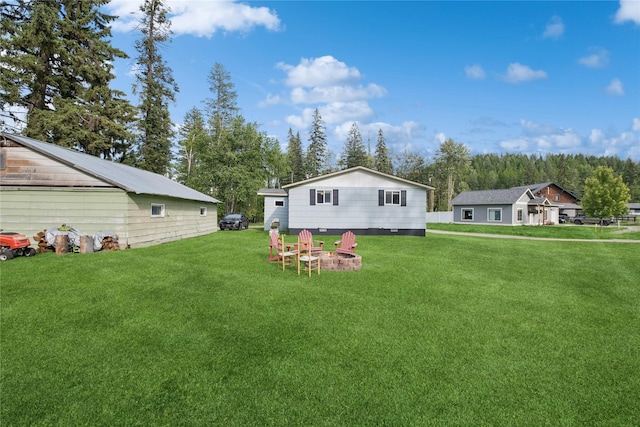 1970 Benchmark Ln, Whitefish, MT 59937 - view of green lawn with an outdoor fire pit and an outbuilding