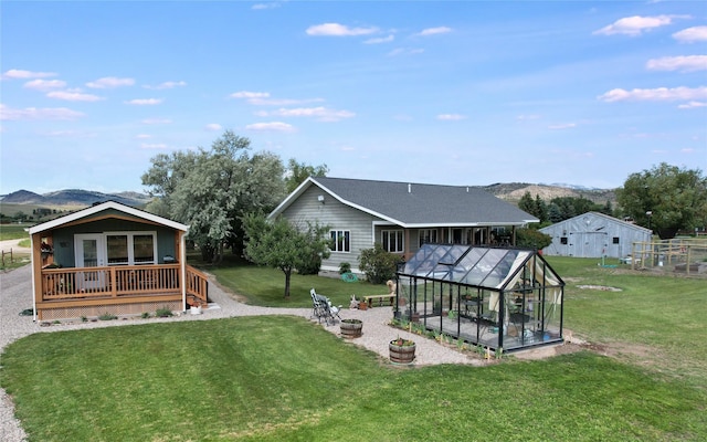 2 Hardy Cir, Ennis, MT 59729 - view of grassy yard featuring a greenhouse, an outdoor structure, and a deck with mountain view