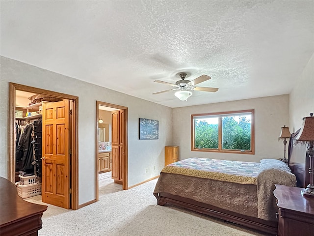 2 Hardy Cir, Ennis, MT 59729 - bedroom with light colored carpet, a spacious closet, a textured ceiling, a ceiling fan, and ensuite bath