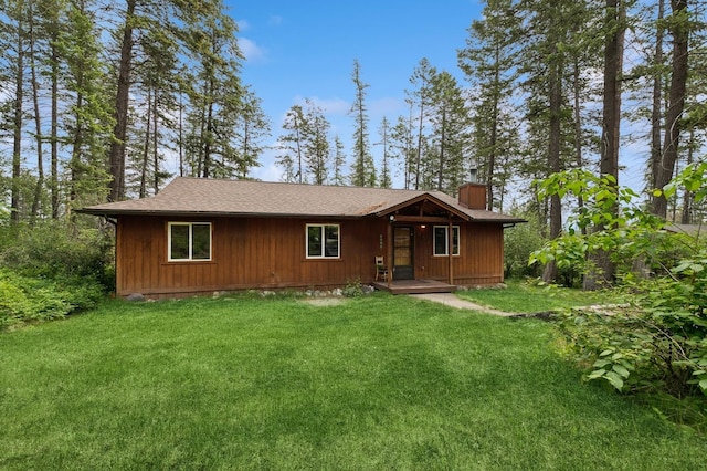257 Fawn Trl, Whitefish, MT 59937 - view of front facade featuring a chimney, a front yard, and roof with shingles