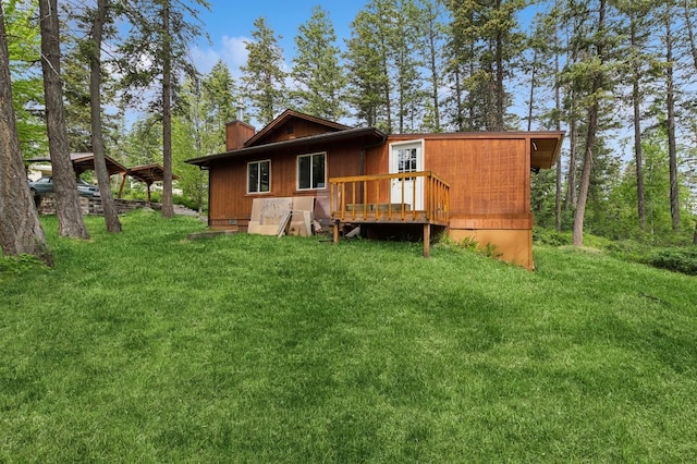 257 Fawn Trl, Whitefish, MT 59937 - back of property with a chimney, a wooden deck, and a lawn