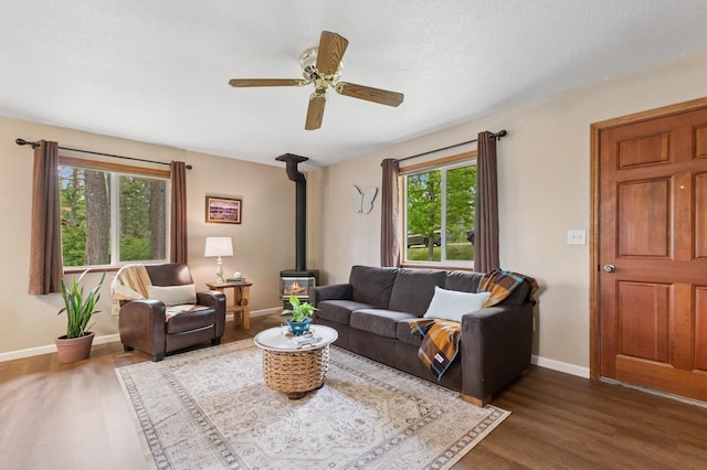 257 Fawn Trl, Whitefish, MT 59937 - living area with a wood stove, dark wood-type flooring, healthy amount of natural light, and a ceiling fan