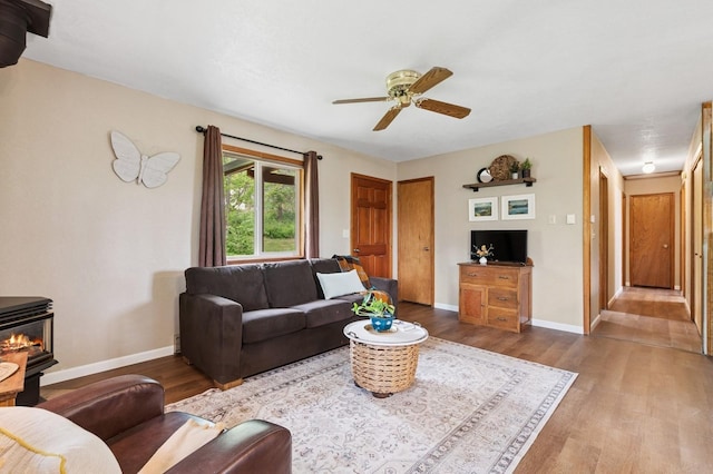 257 Fawn Trl, Whitefish, MT 59937 - living area featuring wood finished floors, a ceiling fan, and a wood stove