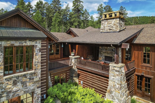 1263 Spencer Ridge Rd, Whitefish, MT 59937 - back of property featuring roof with shingles, stone siding, french doors, a chimney, and board and batten siding