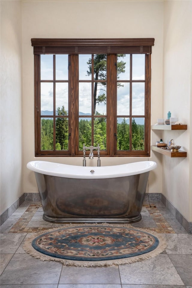 1263 Spencer Ridge Rd, Whitefish, MT 59937 - full bath with stone tile flooring, a freestanding bath, and plenty of natural light