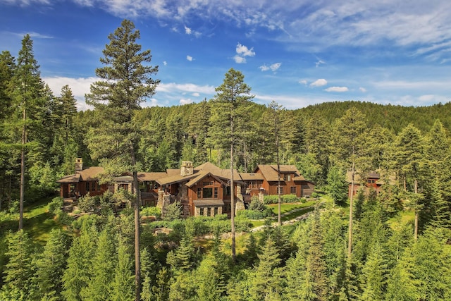 1263 Spencer Ridge Rd, Whitefish, MT 59937 - rear view of house with a view of trees and a chimney