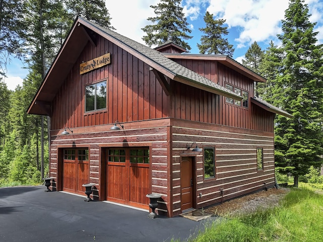 1263 Spencer Ridge Rd, Whitefish, MT 59937 - view of home's exterior featuring roof with shingles, board and batten siding, and a garage