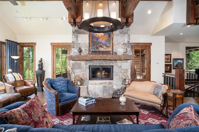 1263 Spencer Ridge Rd, Whitefish, MT 59937 - living room featuring wood finished floors, a stone fireplace, track lighting, high vaulted ceiling, and beamed ceiling