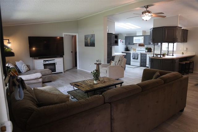 3000 Villard Ave Unit 149, Helena, MT 59601 - living room featuring vaulted ceiling, ornamental molding, light wood-type flooring, and ceiling fan