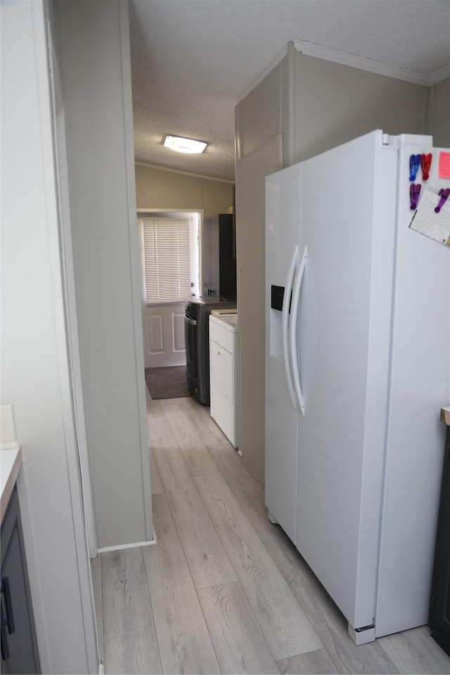 3000 Villard Ave Unit 149, Helena, MT 59601 - kitchen featuring white refrigerator with ice dispenser, washing machine and dryer, a textured ceiling, light countertops, and light wood-style floors