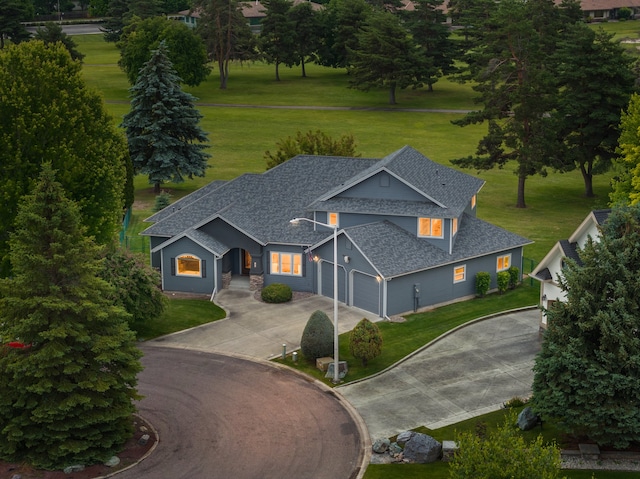 18 Buffalo Hill Cir, Kalispell, MT 59901 - view of front of house with roof with shingles, curved driveway, an attached garage, and a front lawn