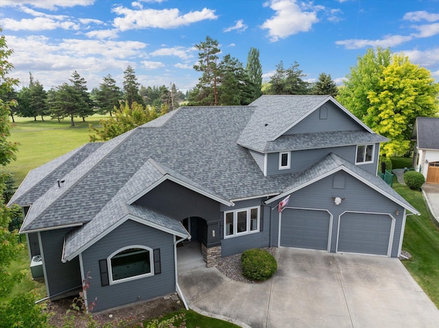 18 Buffalo Hill Cir, Kalispell, MT 59901 - view of front facade featuring an attached garage, roof with shingles, driveway, a front lawn, and view of scattered trees