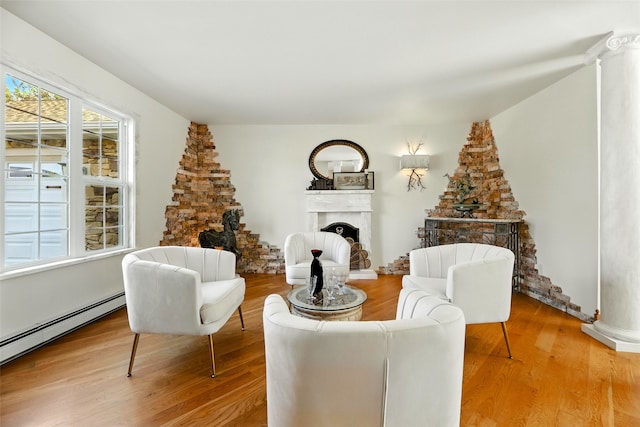 12 Pathfinder Trl, Bozeman, MT 59718 - living area featuring baseboard heating, a fireplace with raised hearth, and wood finished floors