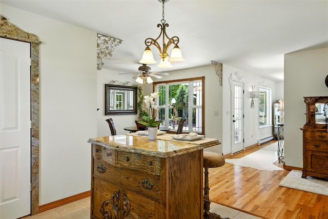 12 Pathfinder Trl, Bozeman, MT 59718 - kitchen with baseboard heating, a breakfast bar, pendant lighting, a center island, and light stone counters