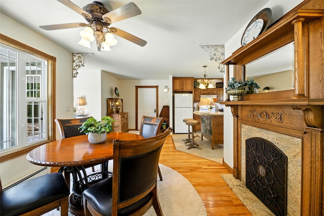 12 Pathfinder Trl, Bozeman, MT 59718 - dining area featuring light wood-type flooring, ceiling fan, a high end fireplace, and baseboard heating