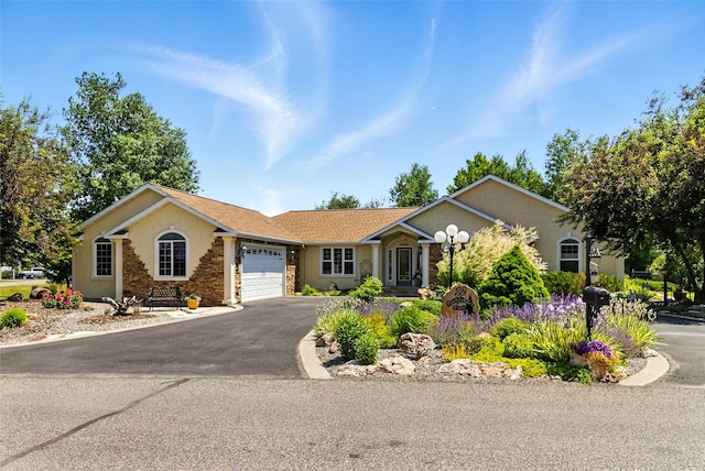 12 Pathfinder Trl, Bozeman, MT 59718 - ranch-style house featuring a garage, driveway, and stucco siding