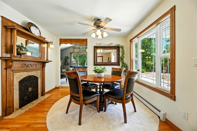 12 Pathfinder Trl, Bozeman, MT 59718 - dining area featuring a baseboard heating unit, light wood finished floors, a ceiling fan, and a high end fireplace