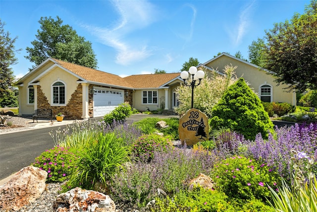 12 Pathfinder Trl, Bozeman, MT 59718 - single story home with stucco siding, an attached garage, stone siding, and concrete driveway