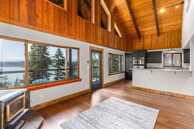 32785 Linden Ln, Bigfork, MT 59911 - living room with high vaulted ceiling, a wood ceiling with exposed beams, wood finished floors, and a wood stove