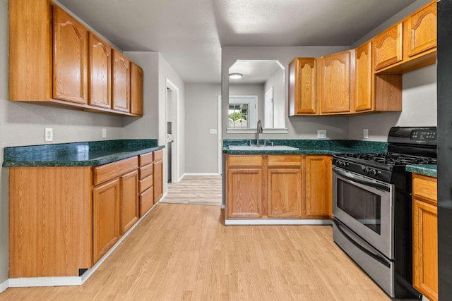 620 N 4th St, Hamilton, MT 59840 - kitchen with gas stove, light wood-type flooring, and dark countertops