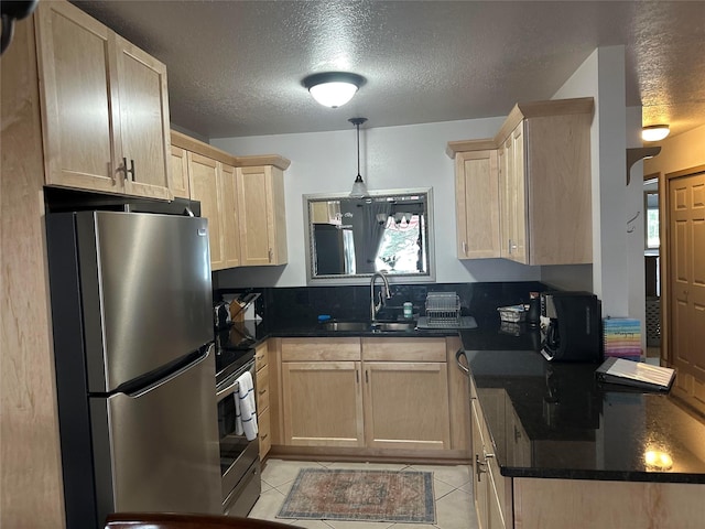 67 Crestwood Dr Unit A, Whitefish, MT 59937 - kitchen with appliances with stainless steel finishes, light brown cabinets, dark countertops, a textured ceiling, and light tile patterned floors
