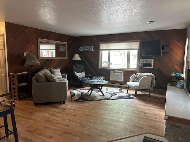 67 Crestwood Dr Unit A, Whitefish, MT 59937 - living room with wooden walls, a textured ceiling, wood finished floors, a wall mounted air conditioner, and a baseboard heating unit