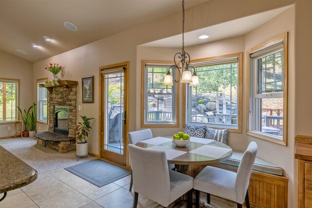 13 Crossfire Dr, Clancy, MT 59634 - tiled dining space with healthy amount of natural light, a stone fireplace, vaulted ceiling, a chandelier, and recessed lighting